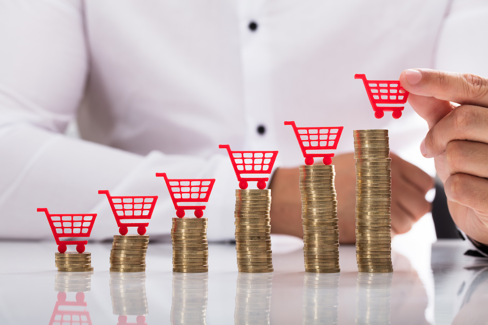 Small shopping carts on coin stacks.