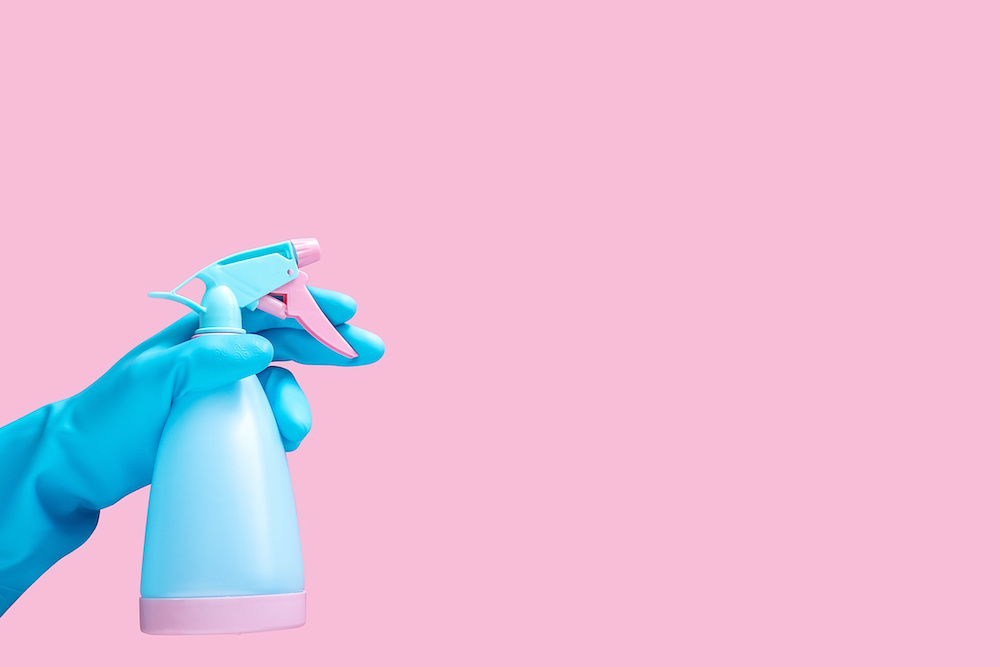 Cleaning bottle in gloved hand