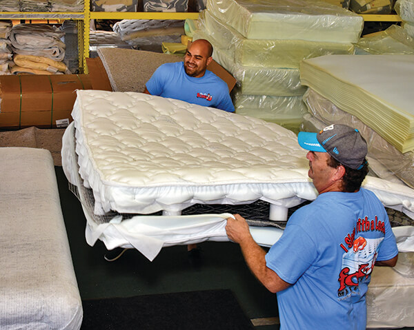 Joe Carter (left) and Brian Westover assemble a mattress, one of the 50 to 60 bed sets Fox Mattress produces each week. 
