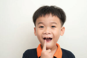 toothless smiling boy showing his lost tooth milk