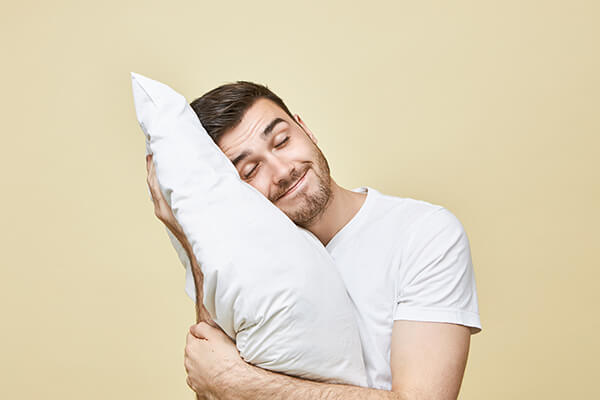 man-cuddling-pillow