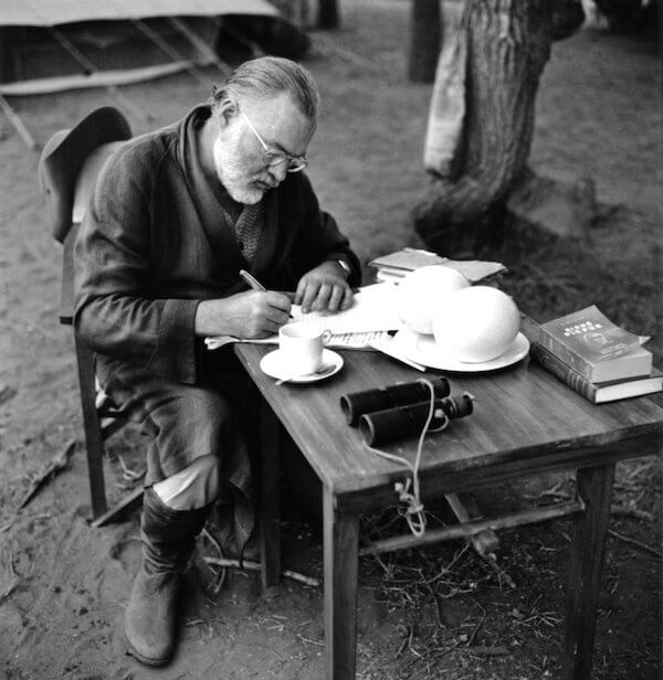 KENYA - SEPTEMBER 1952:  Author Ernest Hemingway writes at a portable table while on a big game hunt in September 1952 in Kenya.  (Photo by Earl Theisen/Getty Images)