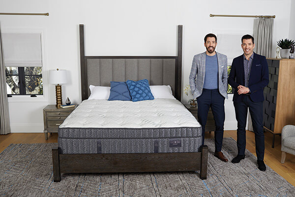 Good Company Drew, left, and Jonathan Scott stand with a Scott Living bed that is part of their licensing program with Restonic.