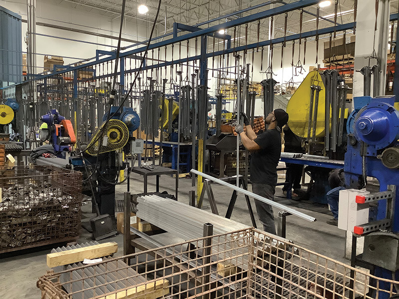 BEHIND THE SCENES A worker at the Rize Home factory in Cleveland attaches bed frame rails to a conveyor line. The rails will later be packaged for shipment to customers.