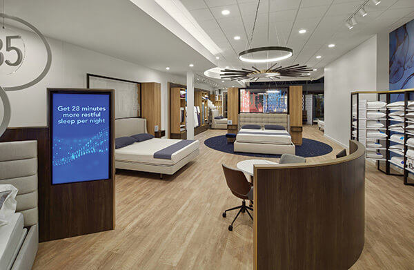 SALES OPENING Shoppers at the redesigned Sleep Number store meet with Sleep Number’s retail sales associates in open settings like this desk area to discuss their individual sleep needs. The RSAs then guide them to the bed best suited for their needs.