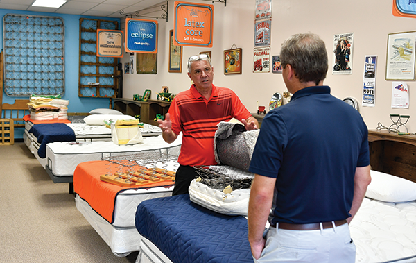CUSTOMER CONNECTIONS When L&W Bedding’s John Wheatley (left) talks to a shopper in his Moline, Illinois, store, he focuses on mattress education and product demonstrations. 

