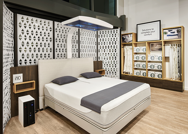 MULTISENSORY SELLING Interactive bed experiences provide “wow” moments in the new Sleep Number store design. The digital screen above this smartbed helps shoppers see, hear and feel how the company’s bed responds to them and their sleep needs.

