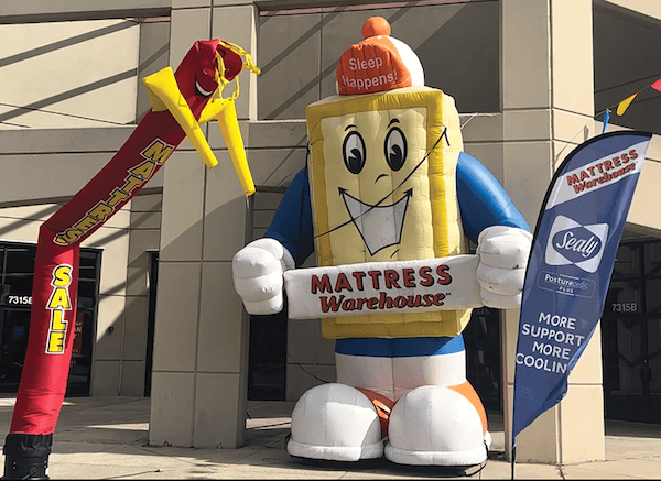 Matty, Mattress Warehouse’s mascot, greets customers outside one of the retailers’ stores in Frederick.