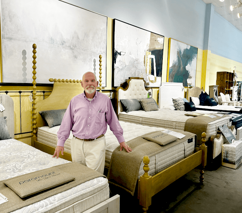 Curated Sleep Shop Success. John Rainey stands among his carefully chosen product mix.