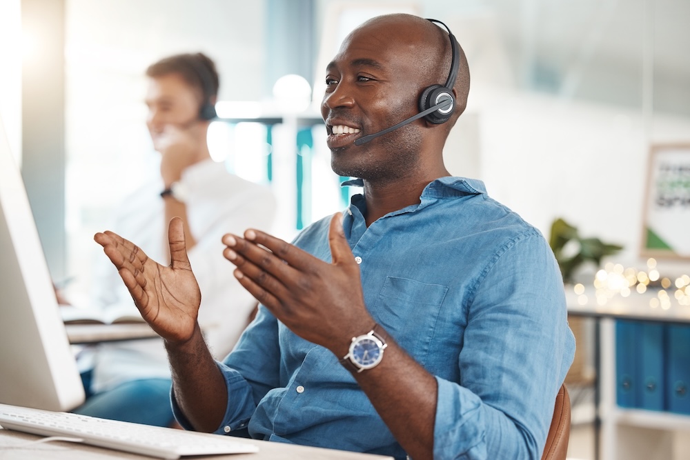 How Speaking Slower Influences. Call center, telemarketing and customer service with a business man working in an office and consulting on a headset. Help, crm and contact us with a black male consult at work on a computer.