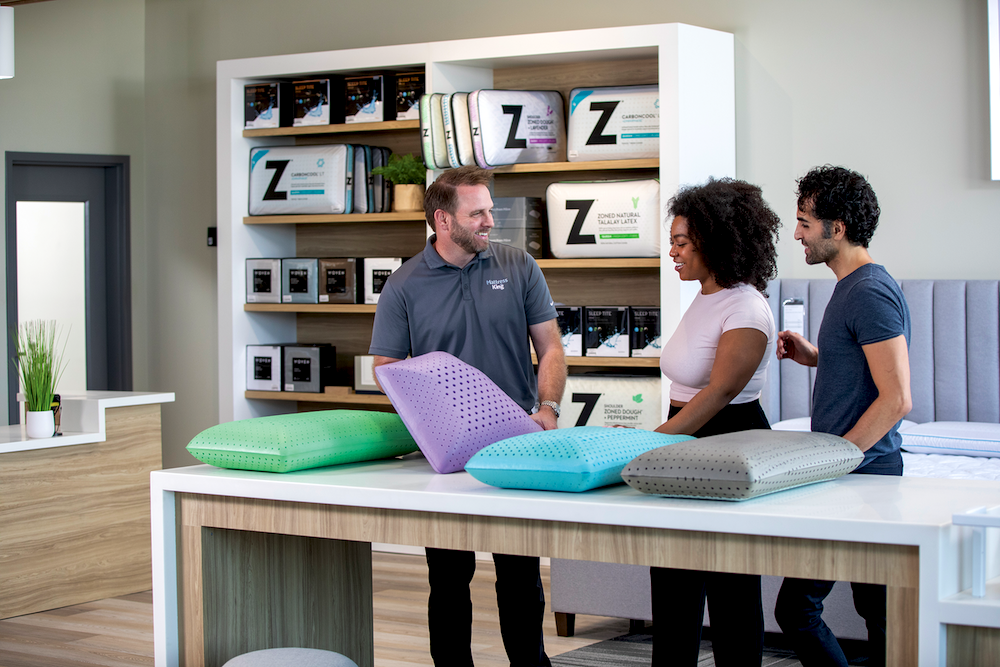 Farris shows shoppers an assortment of pillows